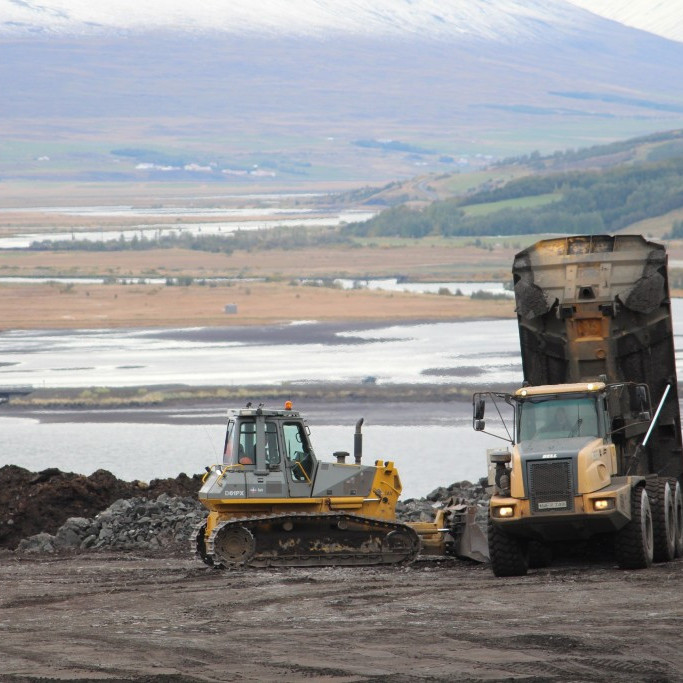 þegar búkollur koma með efni úr göngum er ýta sem tekur við efni og ýtir því í slétt plan og síðan er fylling völtuð/þjöppuð með valtara.